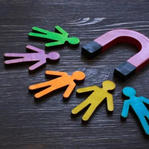 A magnet surrounded by wooden cut out people, to signify staff retention