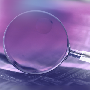A magnifying glass sits atop of a transactions record.