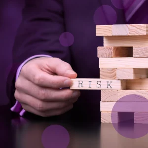 Person pulls wooden block out from a stack of blocks, to depict P2P risk management