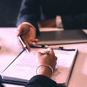 Two people shaking hands over a contract, to signify supplier contracts